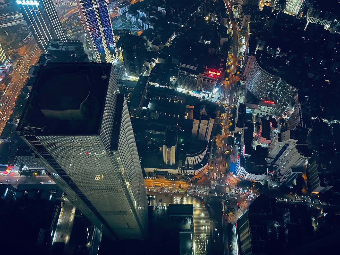 Niccolo Changsha: overnachten in een hotel op 452 meter hoogte 9 Nachtelijk luchtfoto van een stadsgezicht met verlichte straten, hoge wolkenkrabbers en dichte stedelijke bebouwing. -copyright-moving-jack.com