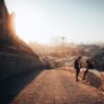 21 unique things to do in erbil 31 how many days to spend in oman Two people sit on a stone wall along a sloping cobblestone path, overlooking erbil's cityscape at sunset, enjoying one of the top things to do in this vibrant destination.