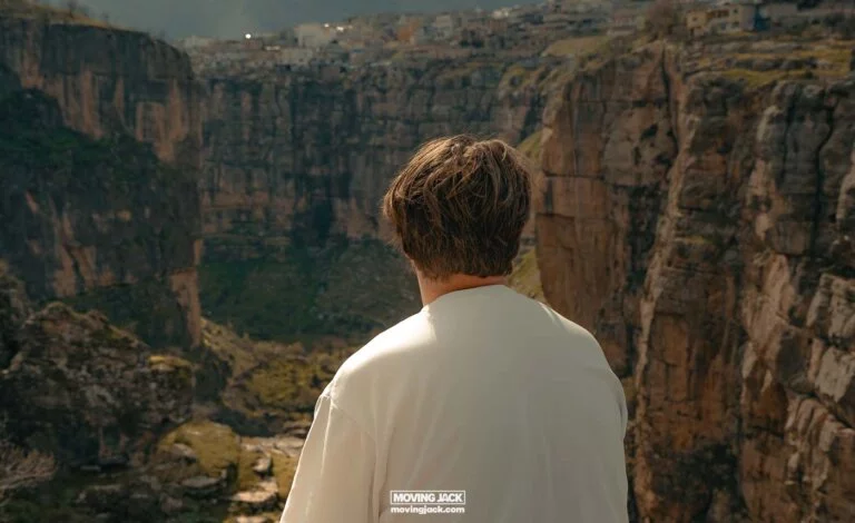 Man visiting Rawanduz, gazing at a deep canyon from the edge.