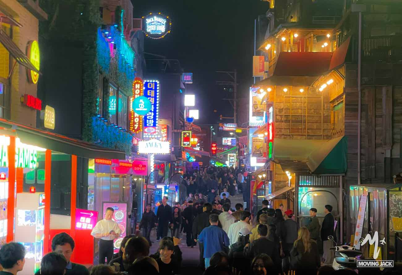Het bruisende nachtleven van Itaewon vult 's nachts de drukke straat met mensenmassa's, neonreclames en felverlichte winkelpanden, wat zorgt voor een elektrische stedelijke sfeer.