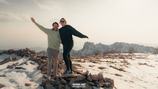 Moving abroad as a couple: pros, challenges & relationship tips 13 moving to south korea with a cat Moving abroad as a couple, two people pose happily on a rocky, snowy hilltop with distant mountains in the background, embracing their shared adventure. -copyright-moving-jack. Com