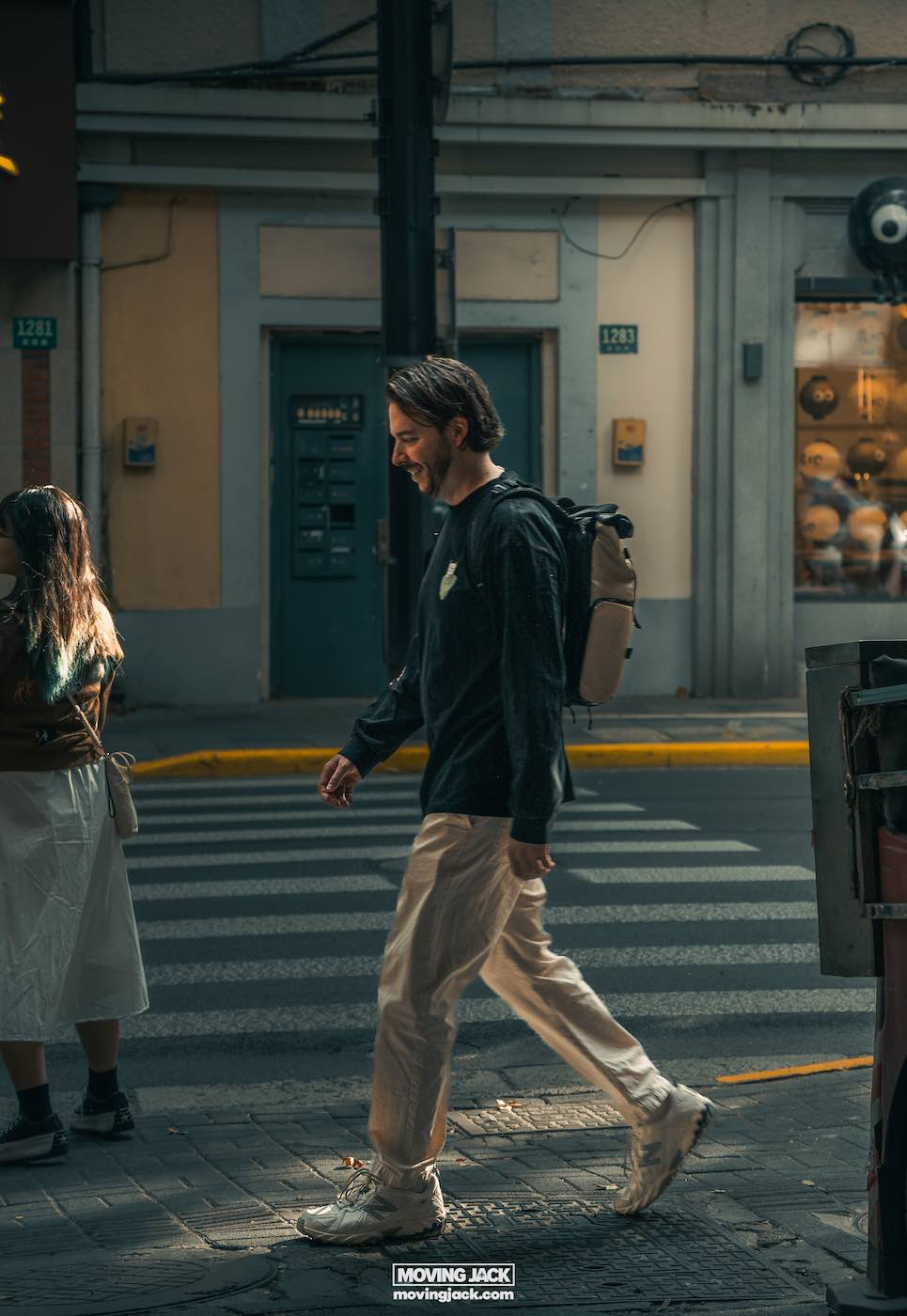 Moving abroad as a couple: pros, challenges & relationship tips 5 moving abroad as a couple A man strolls across a sunlit street, dressed in a black shirt, beige pants, and white sneakers, carrying a backpack. His partner walks alongside him. Perhaps they are visualizing their new life after moving abroad as a couple. Sunlight dances on the buildings in the background. -copyright-moving-jack. Com