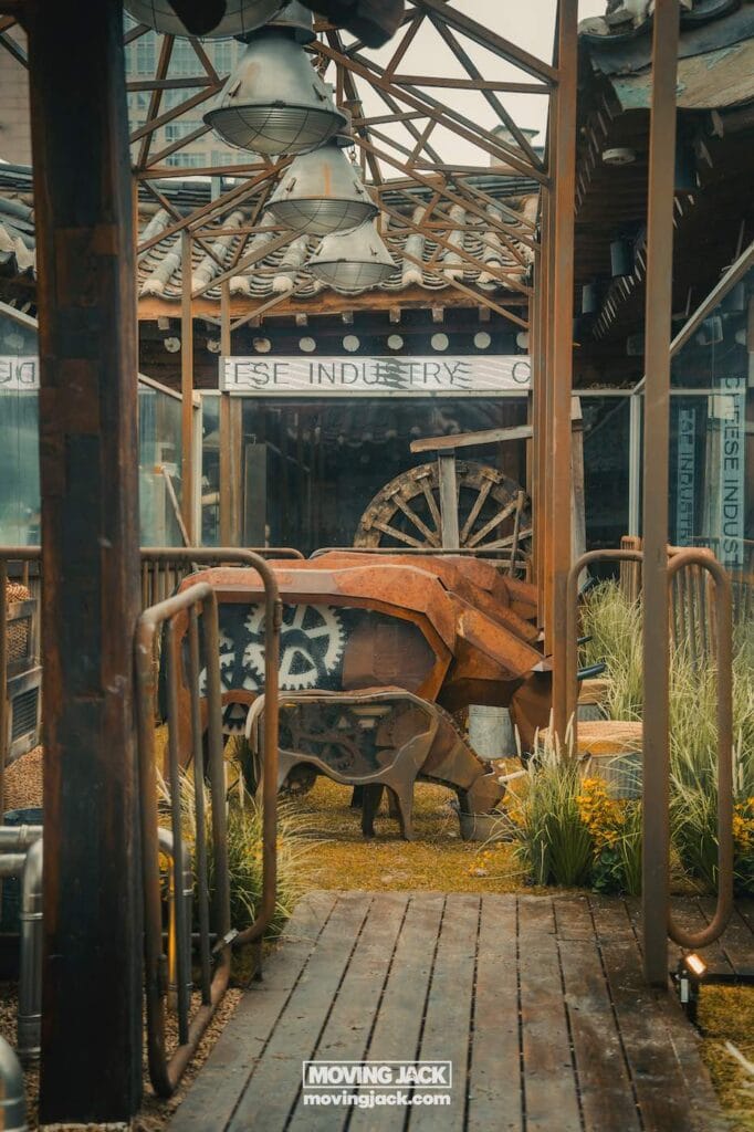 Ikseon dong hanok dorpsroute: waar te eten, drinken en verblijven 16 ikseon dong Een rustieke buitenopstelling in ikseon-dong met metalen constructies, een houten karrewiel en weelderige planten onder industriële verlichting en een charmante houten pergola. -copyright-moving-jack. Com