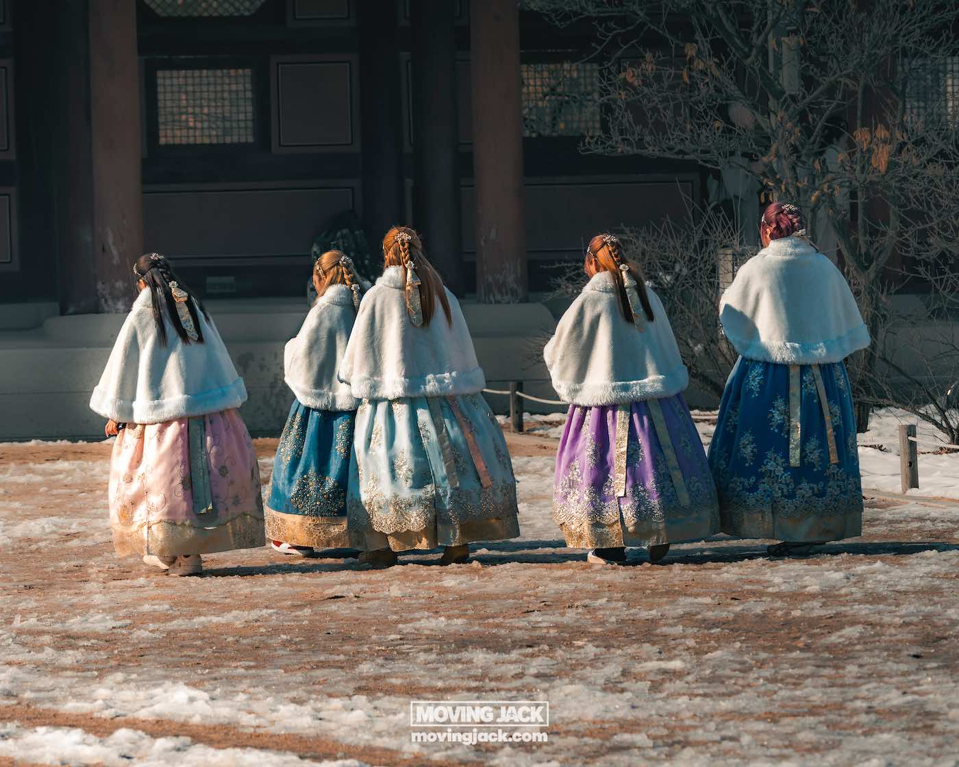 Wat te doen in Seoul: 13 unieke dingen om te doen + wat je beter kunt overslaan! 6 dingen om te doen in Seoul Vijf mensen lopen weg, gekleed in traditionele hanboks en bontjassen. Er ligt sneeuw op de grond en op de achtergrond is een gebouw te zien. -copyright-moving-jack. Com