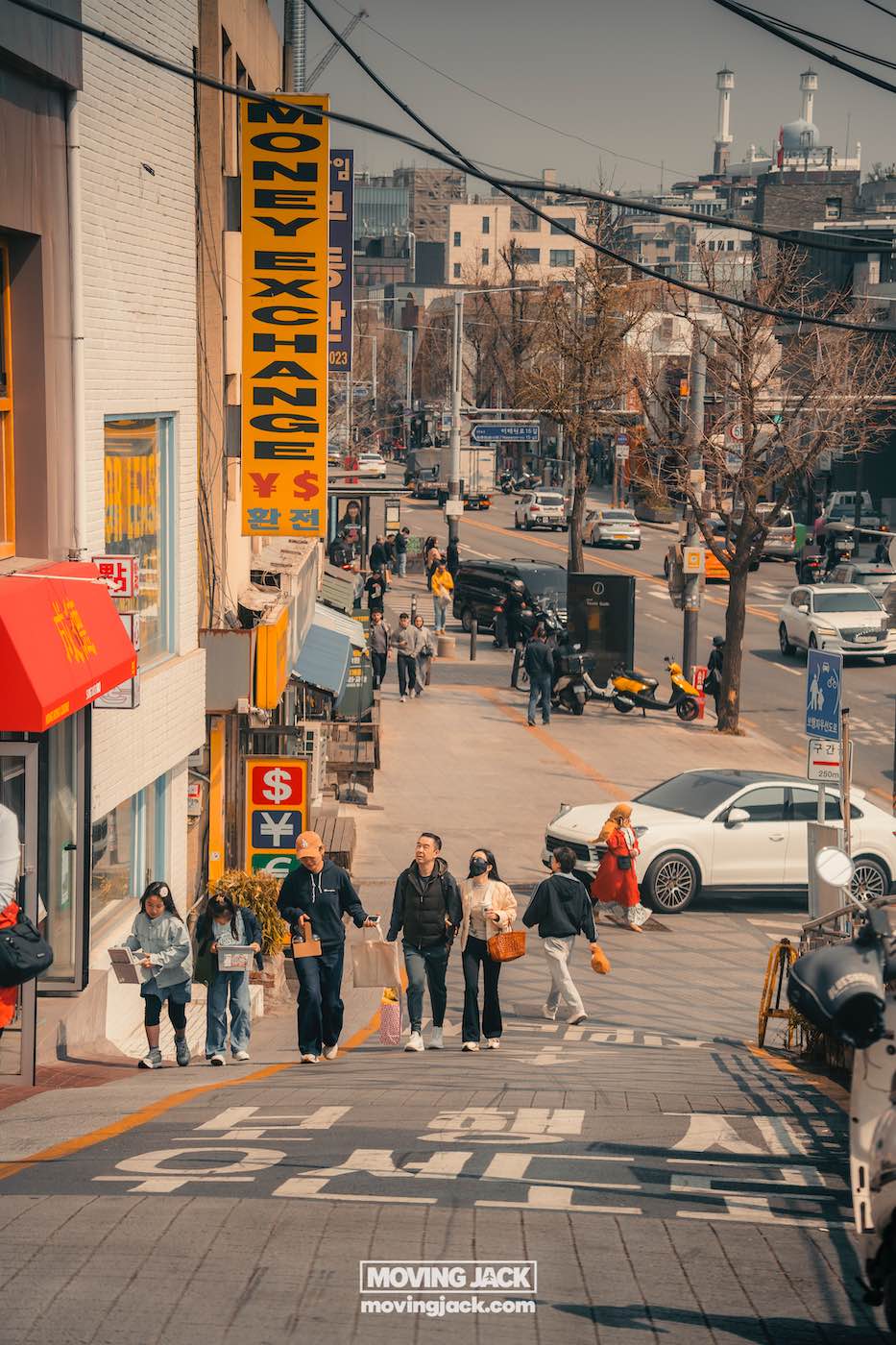Seoul on a budget: save money in south korea 4 seoul on a budget People walking on a street with various shops and signs in an urban area. Cars and motorcycles are visible in the background. -copyright-moving-jack. Com