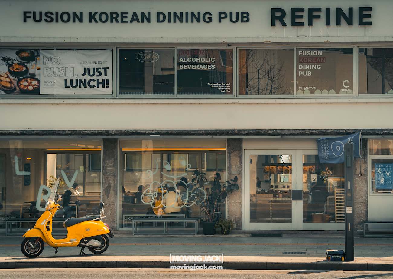 Reisroute Itaewon 2025: de beste eetgelegenheden, drankjes en uitgaansgelegenheden in Itaewon Straatbeeld van een gebouw met een bord met de tekst "refine fusion korean dining pub". Er staat een gele scooter voor geparkeerd. Grote ramen tonen de interieurdecoratie en extra bewegwijzering. -copyright-moving-jack.com