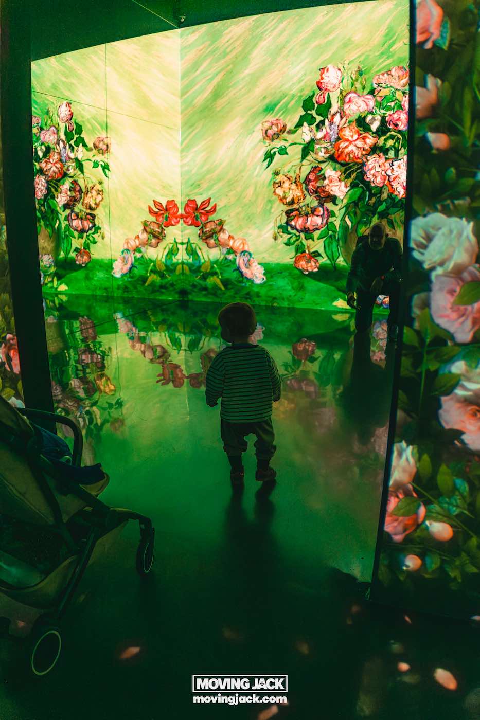 Gemakkelijk weekend in Busan met een peuter: 2-daagse reisroute voor gezinnen van 18 jaar en ouder in Busan, weekend in Busan Een klein kind staat voor felverlichte digitale wanden met kleurrijke bloemenprojecties; een volwassene knielt ernaast. -copyright-moving-jack.com