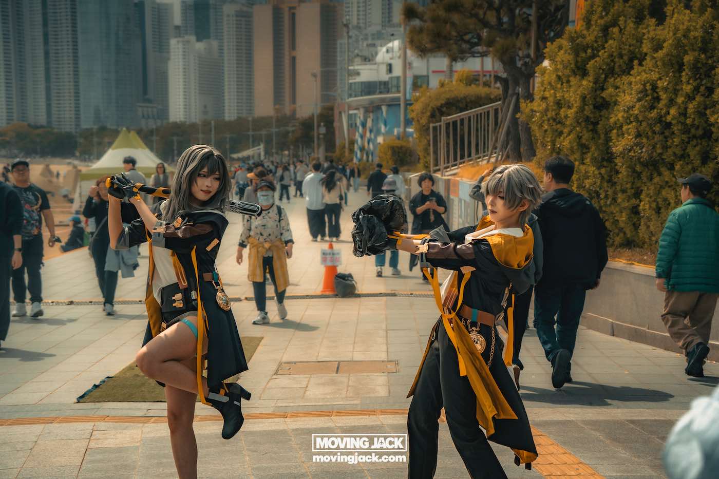 Gemakkelijk weekend in Busan met een peuter: 2-daagse reisroute voor gezinnen 22 Busan,weekend in Busan Twee mensen in zwart-gele kostuums poseren met rekwisieten in een stedelijk buitengebied, terwijl voorbijgangers op de achtergrond lopen. -copyright-moving-jack.com