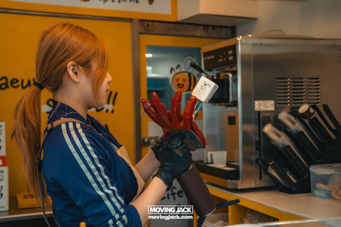 Gemakkelijk weekend in Busan met een peuter: 2-daagse reisroute voor gezinnen 24 Busan,weekend in Busan Een vrouw gebruikt een apparaat in de vorm van een robothand om ijs op een stokje te houden in een winkel. -copyright-moving-jack.com