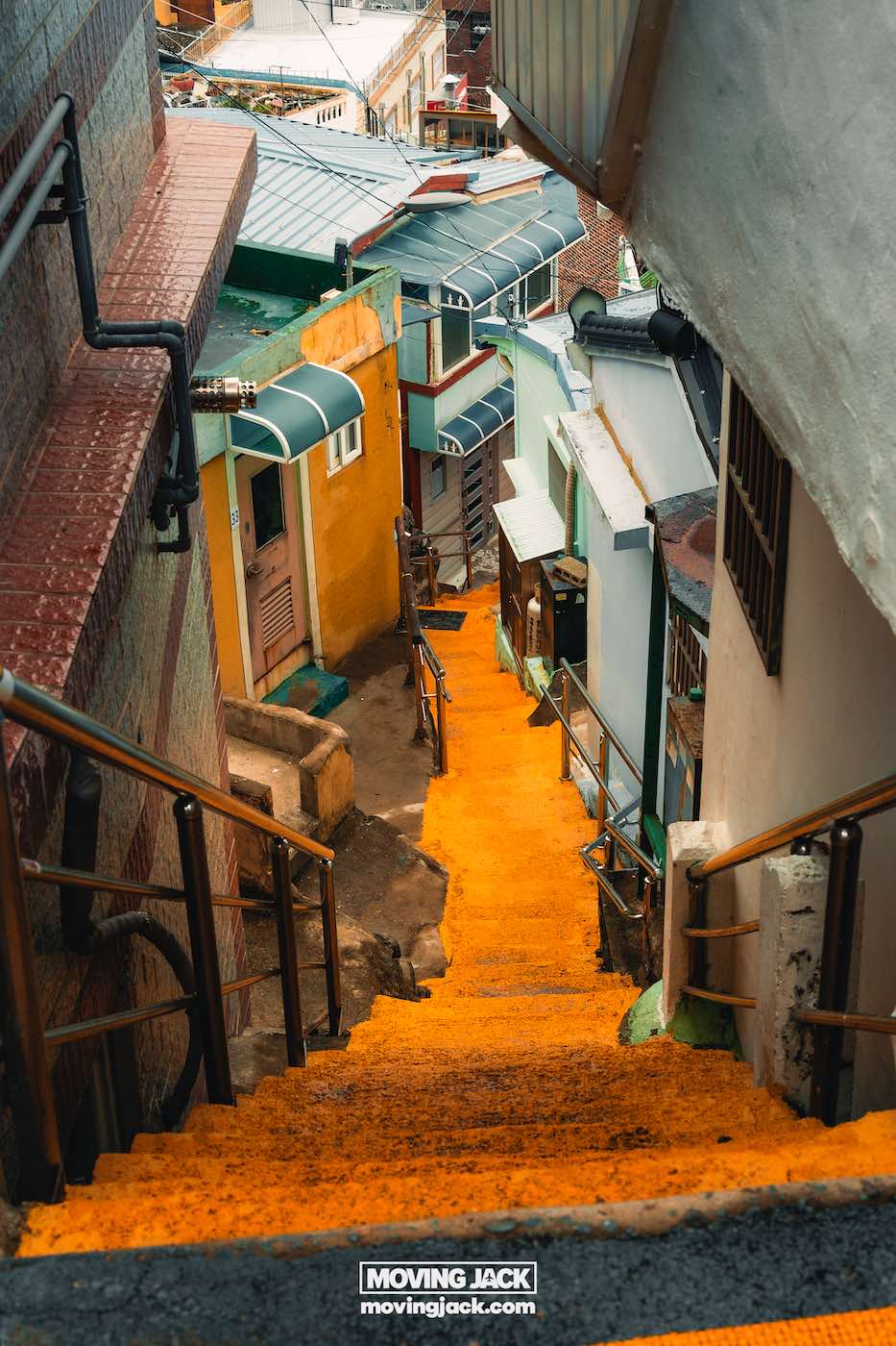 Gemakkelijk weekend in Busan met een peuter: 2-daagse reisroute voor gezinnen 13 Busan,weekend in Busan Een smal steegje met kleurrijke huizen en oranje trappen die tussen de gebouwen afdalen in een stedelijke buurt. -copyright-moving-jack.com