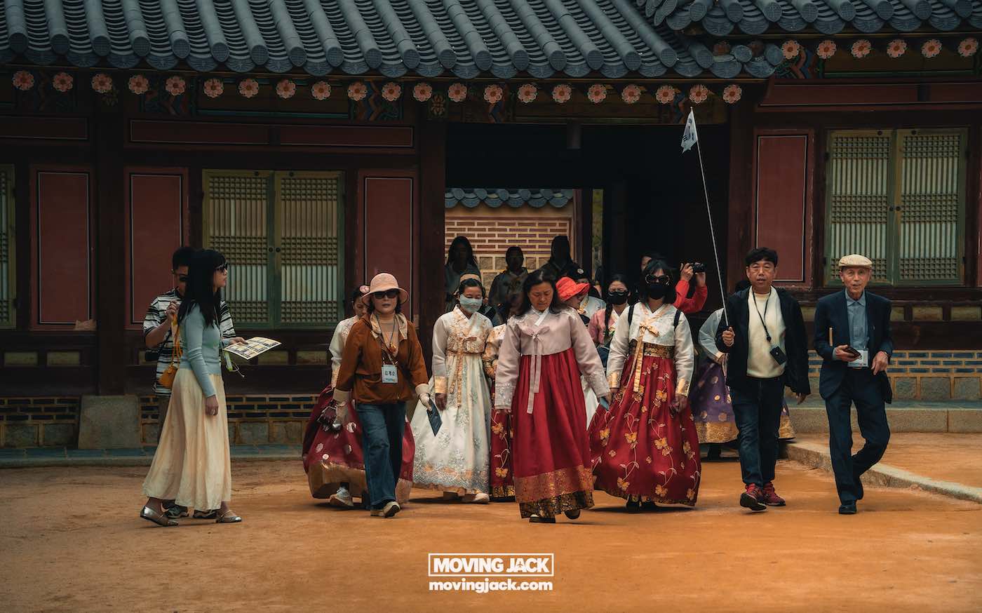 Gyeongbokgung paleis Seoul ultieme gids + wandelvideo 8 Gyeongbokgung Een groep mensen, sommigen gekleed in traditionele Koreaanse hanbok, loopt samen in een binnenplaats bij Gyeongbokgung, een historisch Koreaans gebouw. -copyright-moving-jack.com
