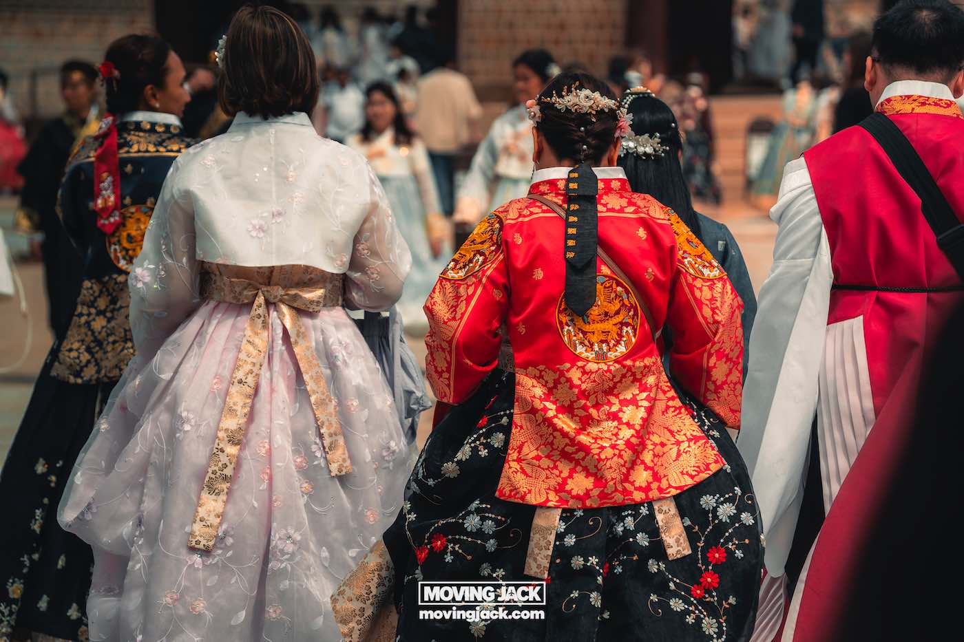 Gyeongbokgung paleis Seoul ultieme gids + wandelvideo 3 Gyeongbokgung Een groep mensen gekleed in traditionele Koreaanse hanbok loopt samen in de buurt van Gyeongbokgung. Op hun kleding zijn sierlijke patronen en felle kleuren zichtbaar. -copyright-moving-jack.com