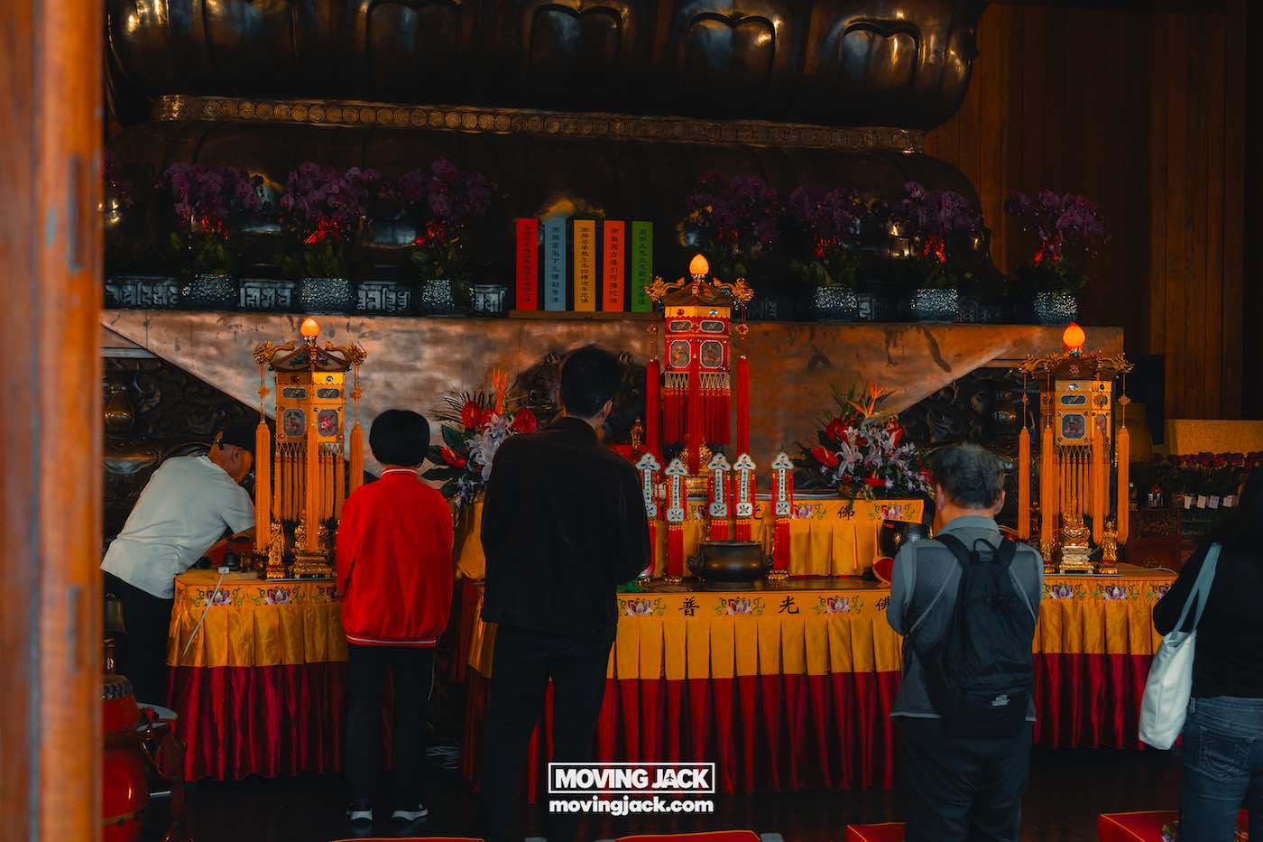 Waar te verblijven in Shanghai: 5 leukste wijken + beste hotels 41 waar te verblijven in Shanghai Verschillende mensen staan te bidden voor een rijkversierd altaar met wierook en offergaven in een tempelomgeving, een vredige plek die vaak wordt bezocht door mensen die op zoek zijn naar een slaapplek in Shanghai. -copyright-moving-jack.com