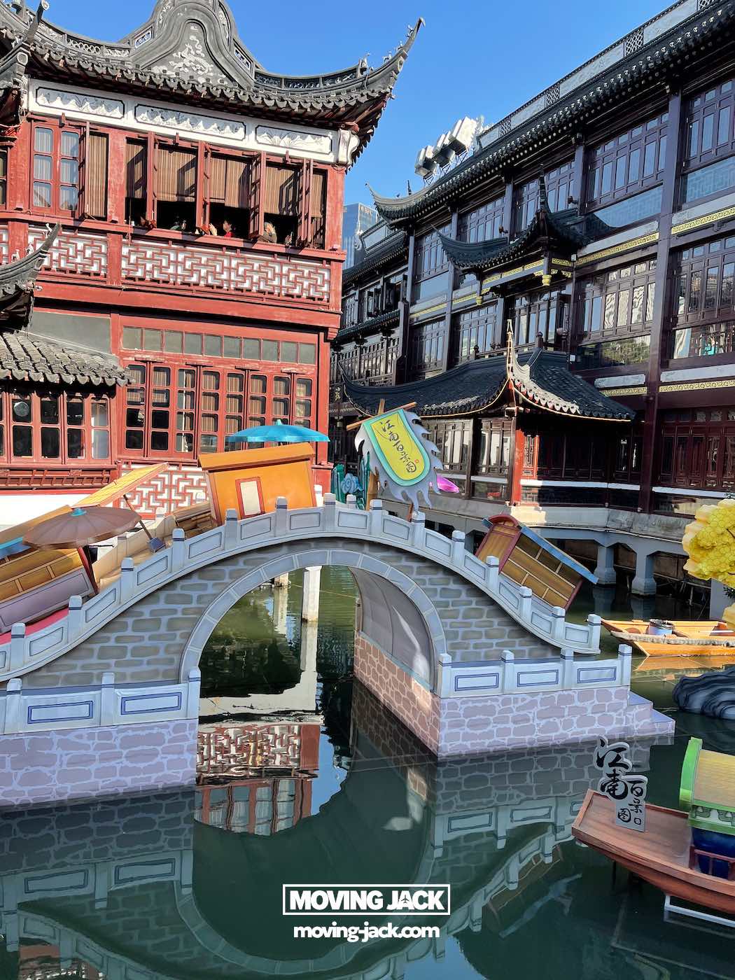 Is je tuin een bezoek waard in 2025? Complete gids & eerlijke lokale review 6 Is je tuin een bezoek waard? Een decoratieve stenen boogbrug overspant een waterweg, omringd door traditionele Chinese architectuur. Kleurrijke verhuisdozen met het opschrift "moving jack" (verhuiskrik) verwijzen naar de levendige sfeer – een treffende weergave van waarom uw tuin een bezoek waard is. -copyright-moving-jack.com
