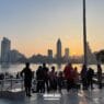 15 unique things to do in shanghai near the bund 97 things to do in shanghai A group of people stands on a city waterfront promenade at sunset, with tall buildings and a river in the background, capturing the vibrant energy of shanghai at night. -copyright-moving-jack. Com