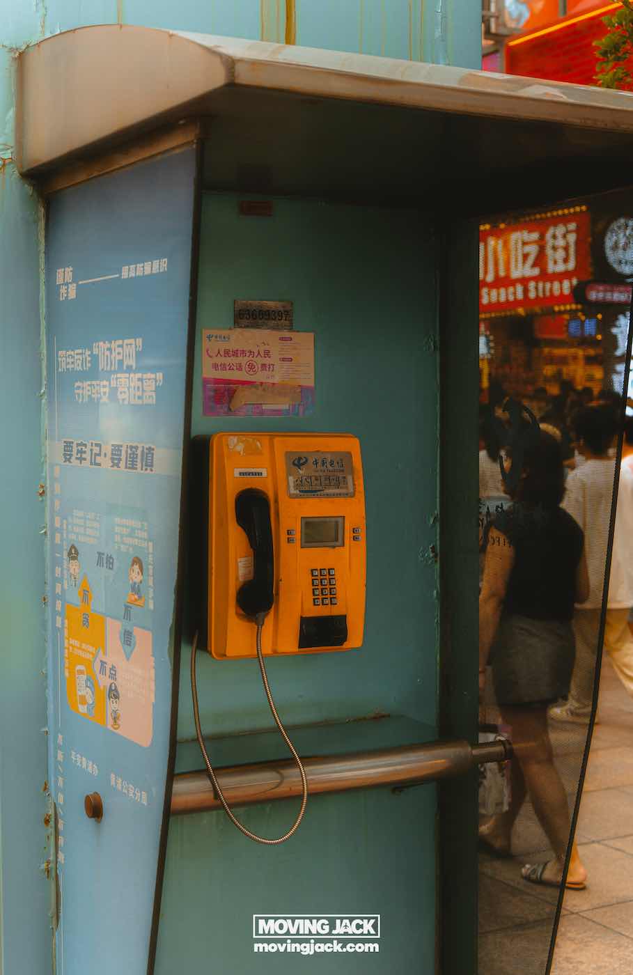57 things to do in shanghai: the ultimate handbook 47 things to do in shanghai A yellow public payphone is mounted inside a booth on a busy street in shanghai at night, with informational posters and pedestrians visible in the background. -copyright-moving-jack. Com