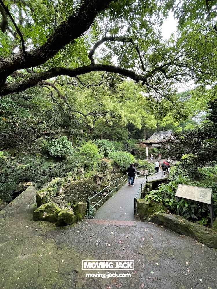 57 things to do in shanghai: the ultimate handbook 44 things to do in shanghai People walk along a stone path by a pond in hangzhou, green traditional chinese garden with trees and a small pavilion—showing the tranquil beauty and traditional architecture that make this historic site a tranquil highlight among the best things to do in shanghai. -copyright-moving-jack. Com