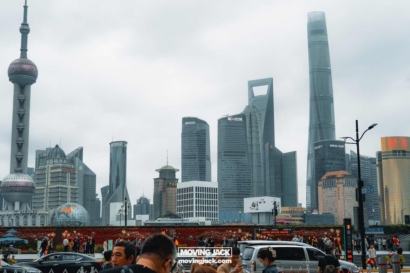 15 unique things to do in shanghai near the bund 3 things to do in shanghai near the bund Skyline view of shanghai’s pudong district with modern skyscrapers including the shanghai tower, under a cloudy sky; crowds and traffic visible in the foreground. -copyright-moving-jack. Com