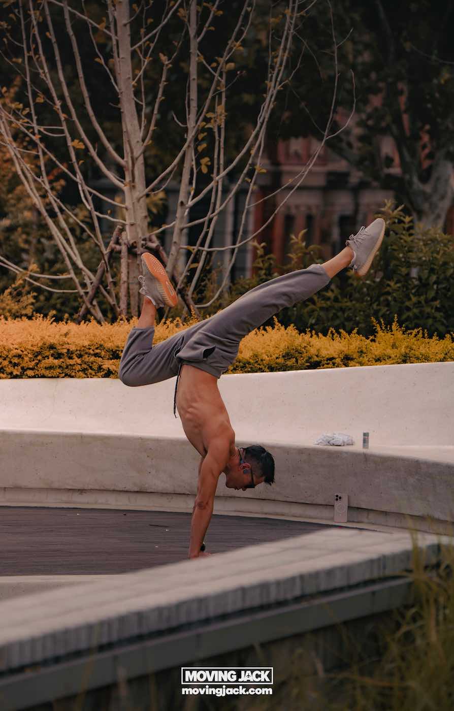15 unique things to do in shanghai near the bund 17 things to do in shanghai near the bund A shirtless man performs a handstand outdoors on a wooden platform near plants and bushes, with his legs extended in the air. -copyright-moving-jack. Com