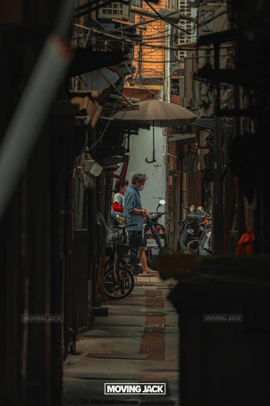 20+ best things to do in taipei (by an expert) 13 things to do in taipei A man stands with a bicycle in a narrow, dimly lit alleyway in taipei, lined with parked motorcycles and cluttered with wires and pipes. Warm light filters through at the far end—a scene straight from the best things to do in taipei list. "moving jack" appears below. -copyright-moving-jack. Com