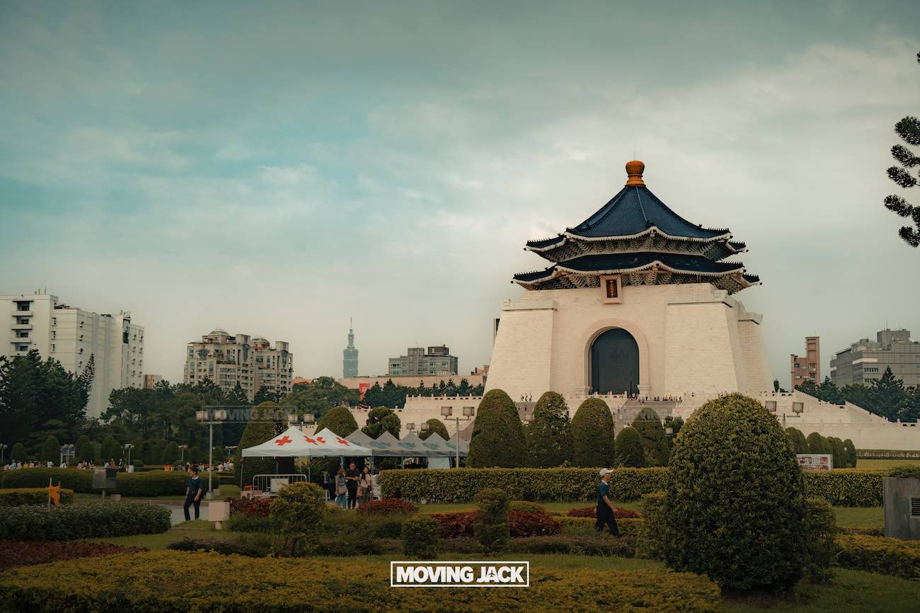 20+ best things to do in taipei (by an expert) 10 things to do in taipei A large white traditional building with a blue tiled roof and arched doorway stands in a landscaped park, one of the best things to do in taipei, with trimmed bushes, people walking, and city buildings visible under a cloudy sky. -copyright-moving-jack. Com