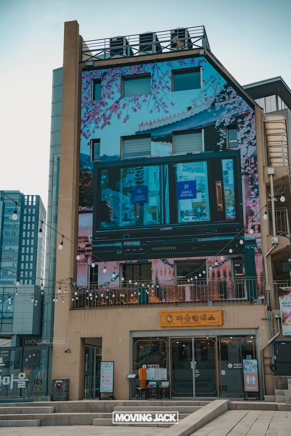 31 best free & cheap things to do in seoul (by an expert) 19 free things to do in seoul A modern building features a large digital screen displaying advertisements above shops with signs, surrounded by string lights and city buildings—perfect for exploring some free things to do in seoul. -copyright-moving-jack. Com