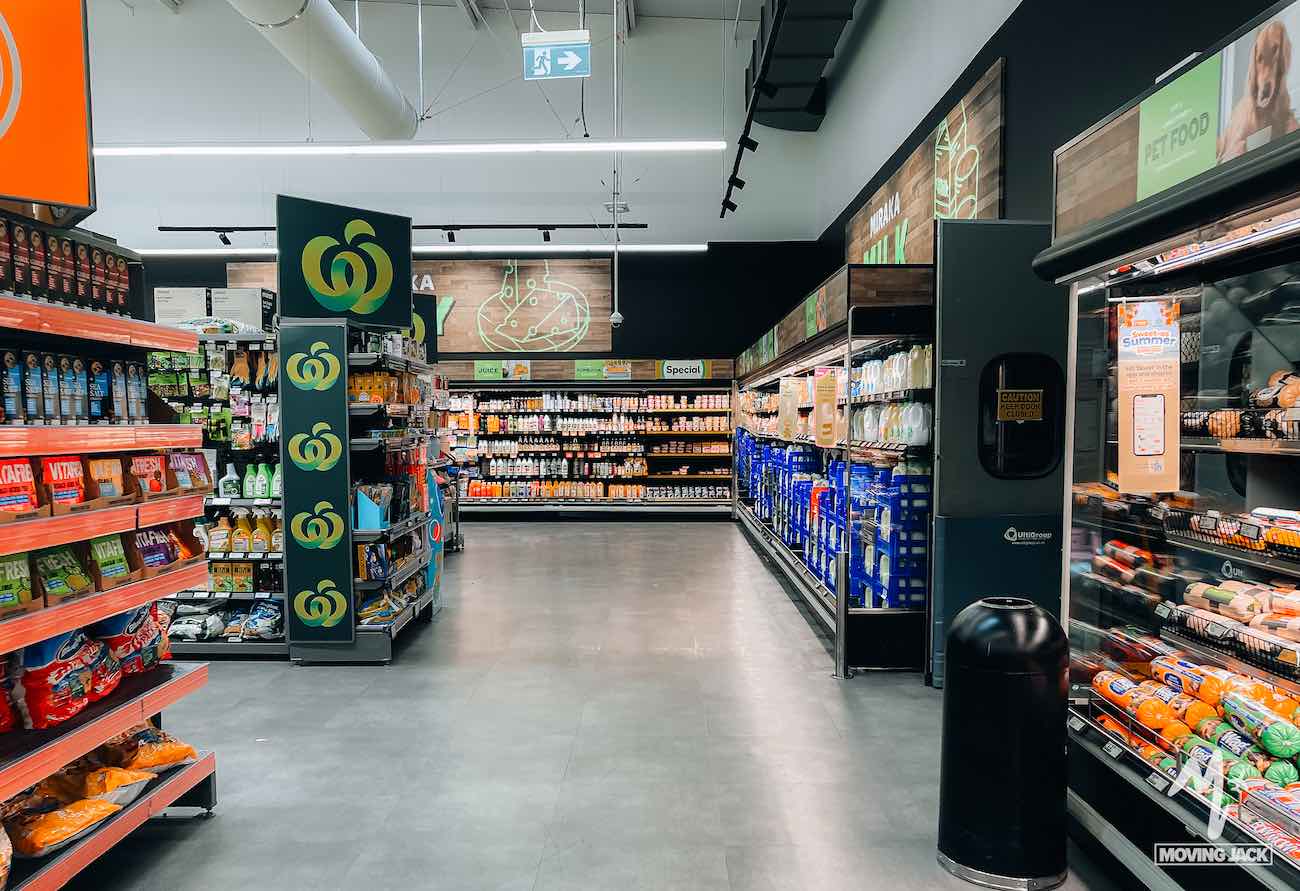 Aisles of a brightly lit supermarket with shelves stocked with groceries and drinks, perfect for travelers wondering, "Is New Zealand by campervan worth it?.
