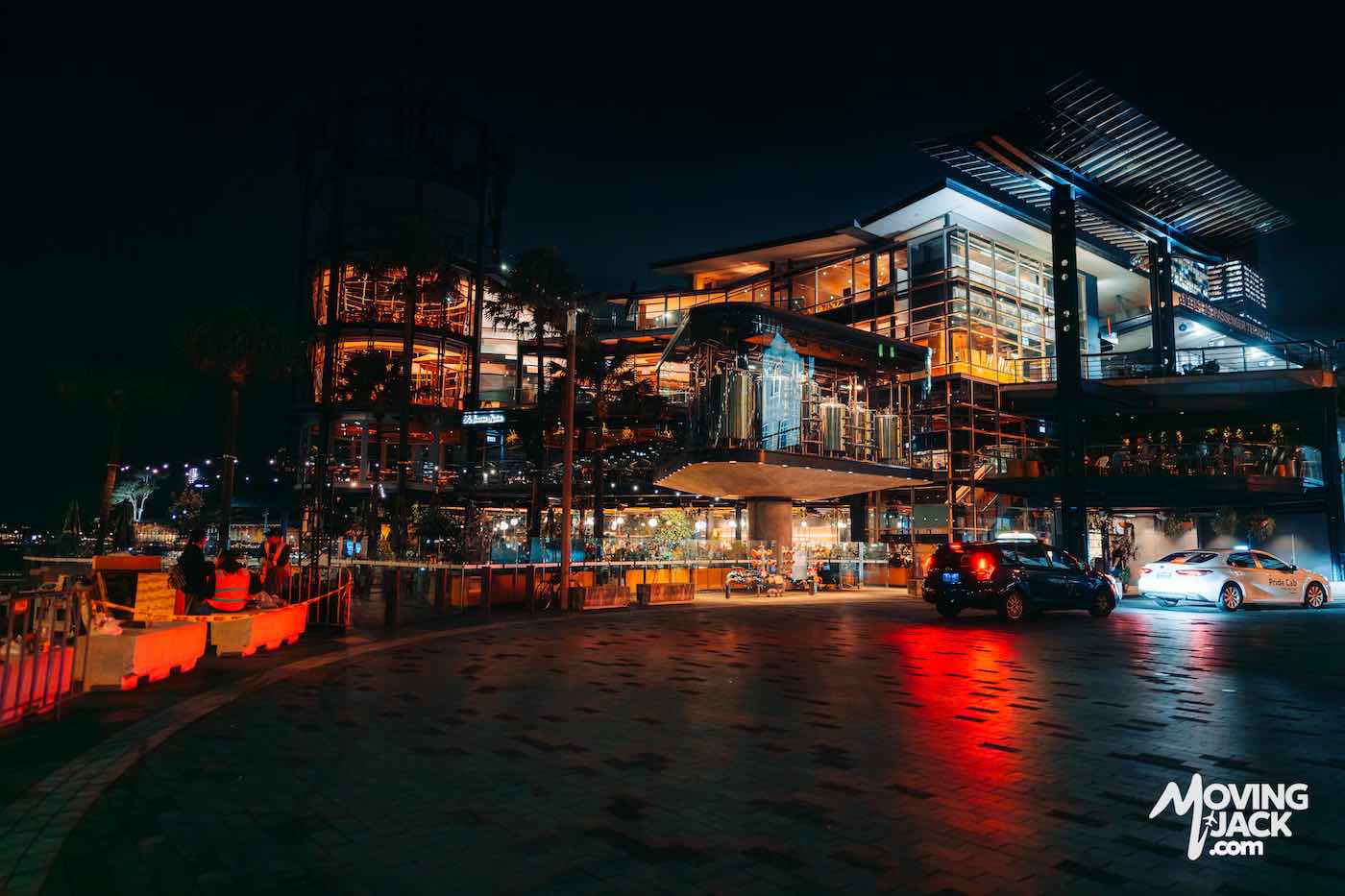 Modern waterfront building lit up at night.