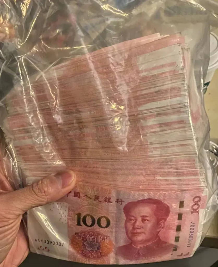 A person holding a bag of Chinese currency while working at a Chinese company.