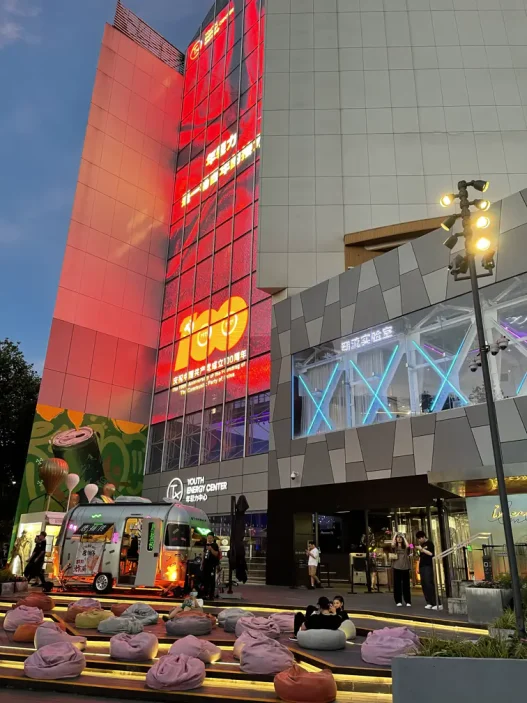 A bustling gathering of people near a prominent structure.